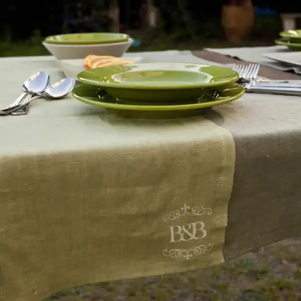Tovaglia di lino verde con monogramma.