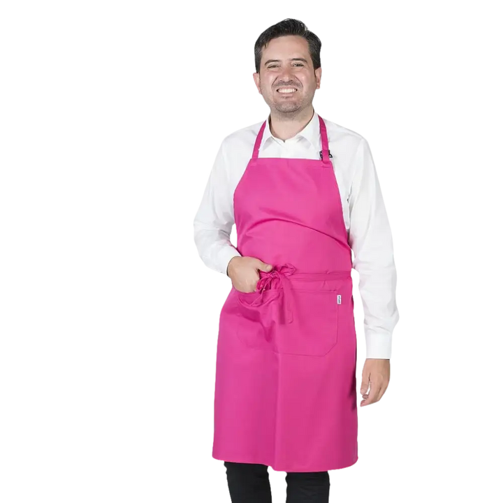 Un uomo che indossa un grembiule integrale rosa fucsia con tasca frontale e laccetto regolabile al collo.