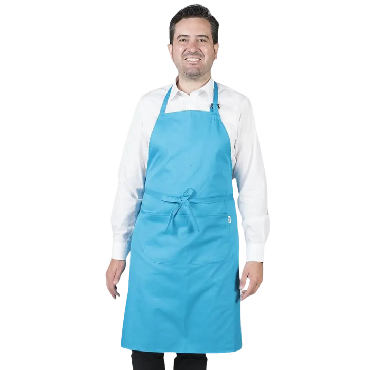 Un uomo sorridente che indossa un grembiule azzurro e una camicia bianca.