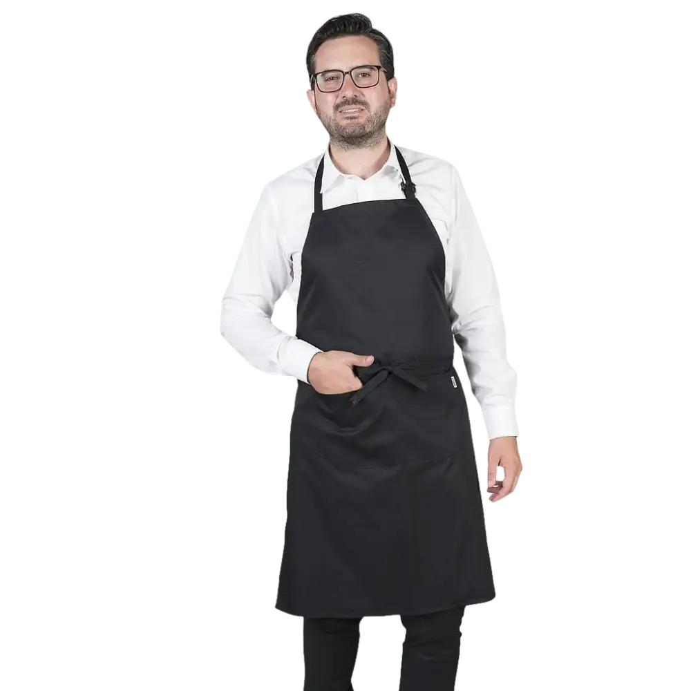 Un uomo che indossa un grembiule nero e una camicia bianca.