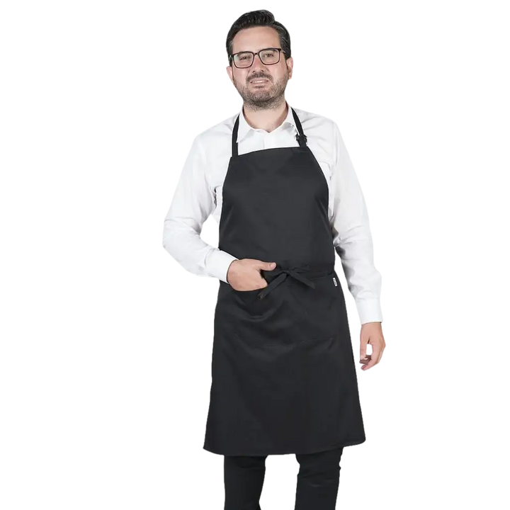 Un uomo che indossa un grembiule nero e una camicia bianca.