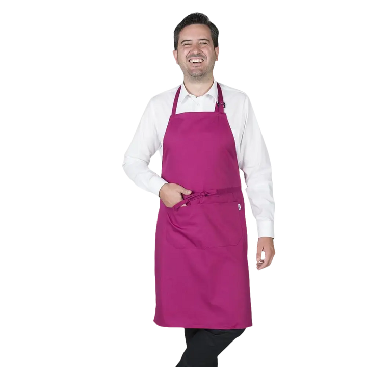 Un uomo indossa un vivace grembiule color magenta con un laccetto regolabile al collo e un laccetto in vita.