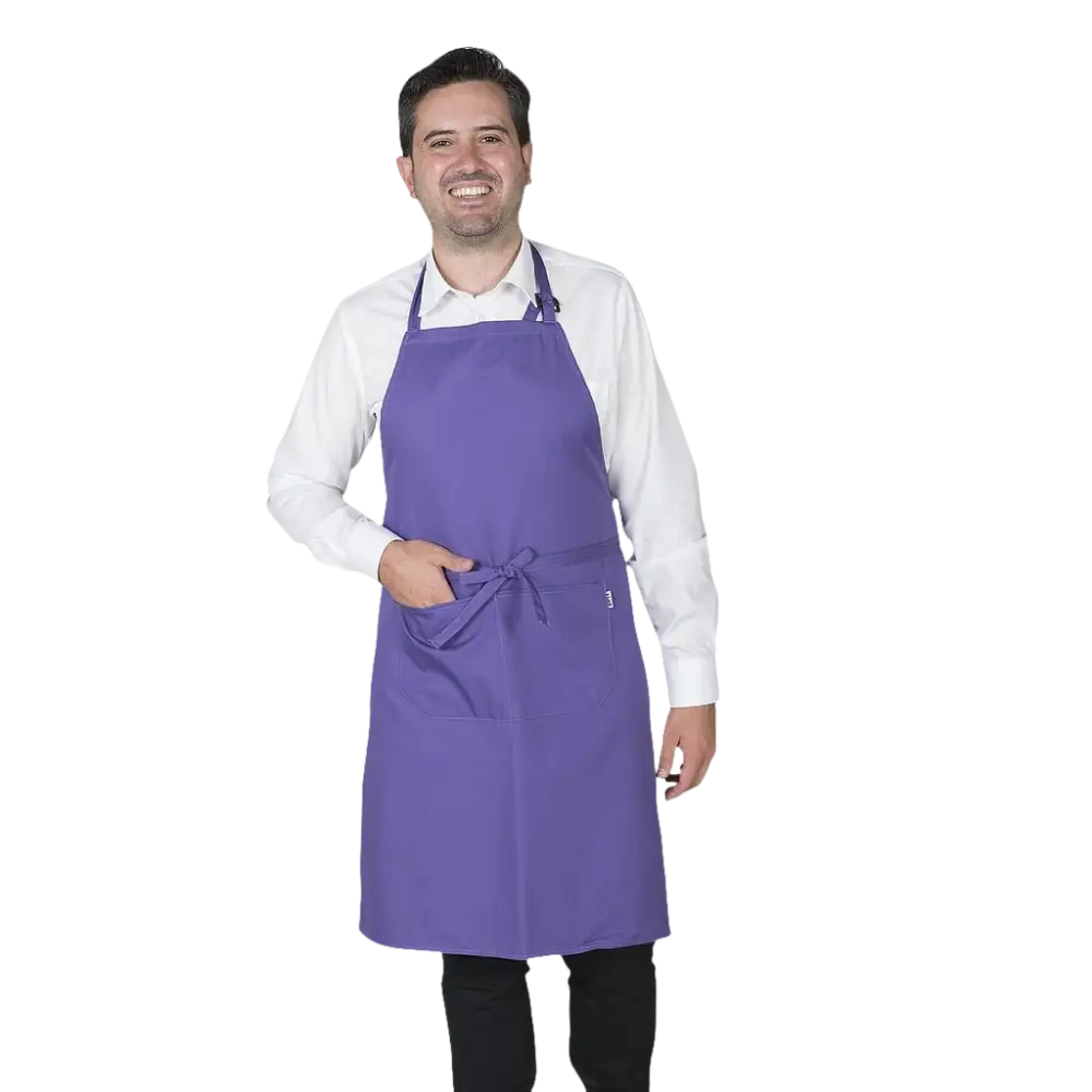 Un uomo sorridente che indossa un grembiule viola su una camicia bianca e pantaloni neri.